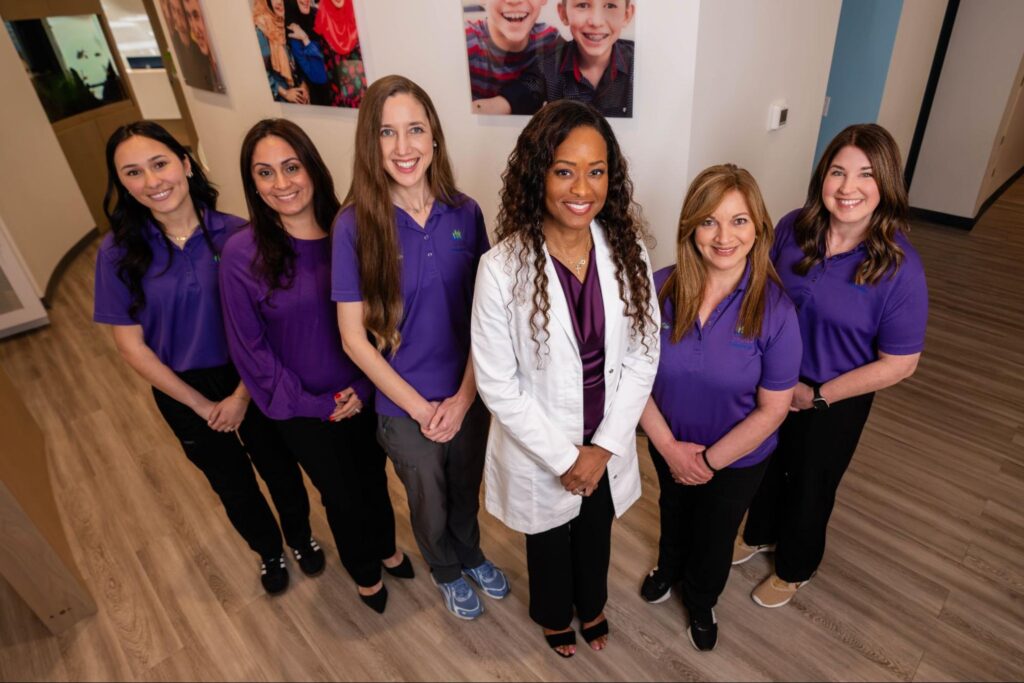Team of orthodontic professionals at MyFamily Orthodontics in Orlando, wearing purple uniforms, smiling in a welcoming office environment, emphasizing clear communication and care for families seeking braces and clear aligners.