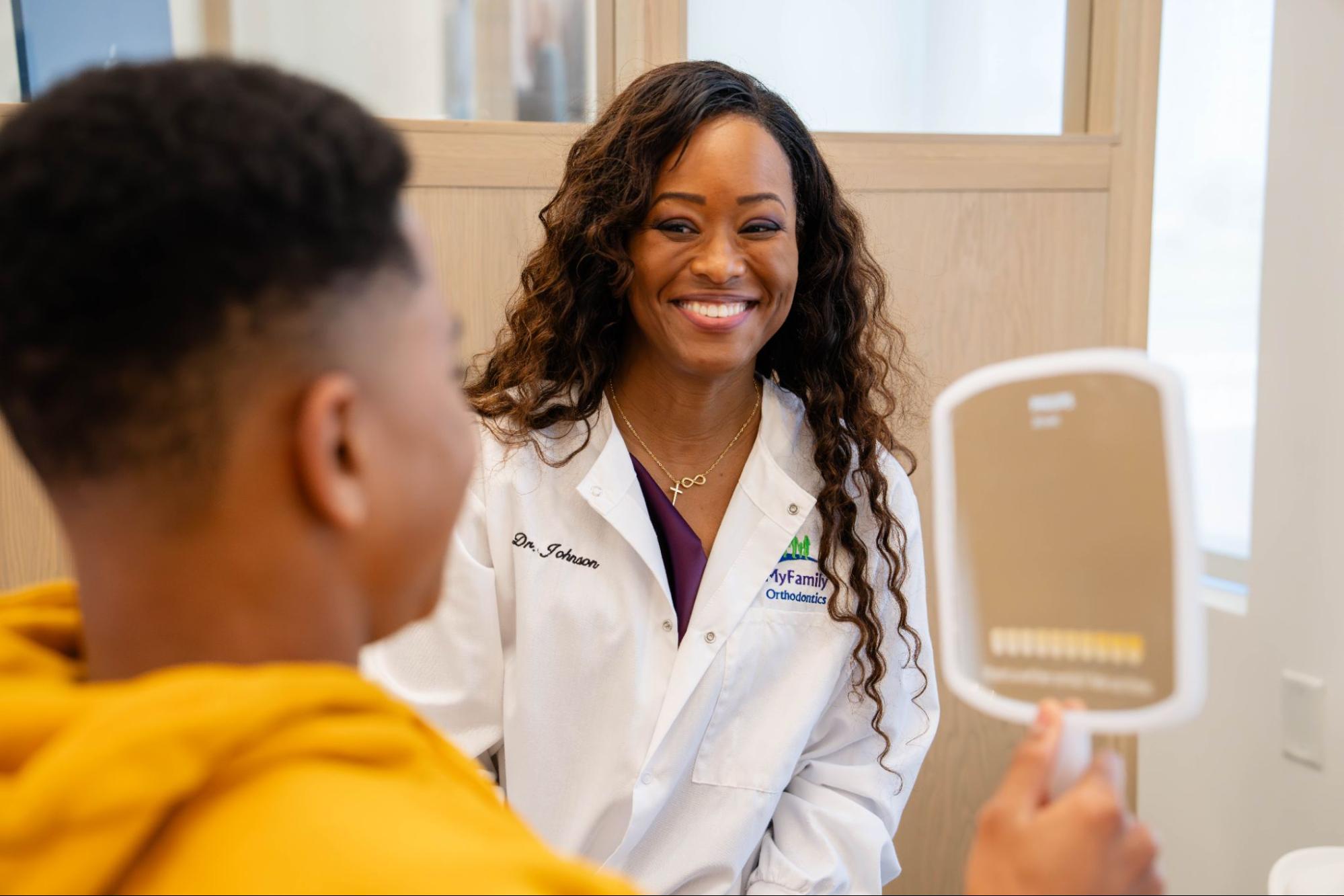 Dr. Johnson smiling at a young patient in a MyFamily Orthodontics office, discussing braces and clear aligners in Orlando.